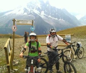 Adolescents en cours de VTT de descente avec moniteur face au Mont-Blanc